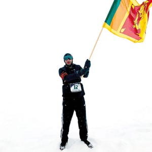 Hassan Esufally on the snow, waving a flag.