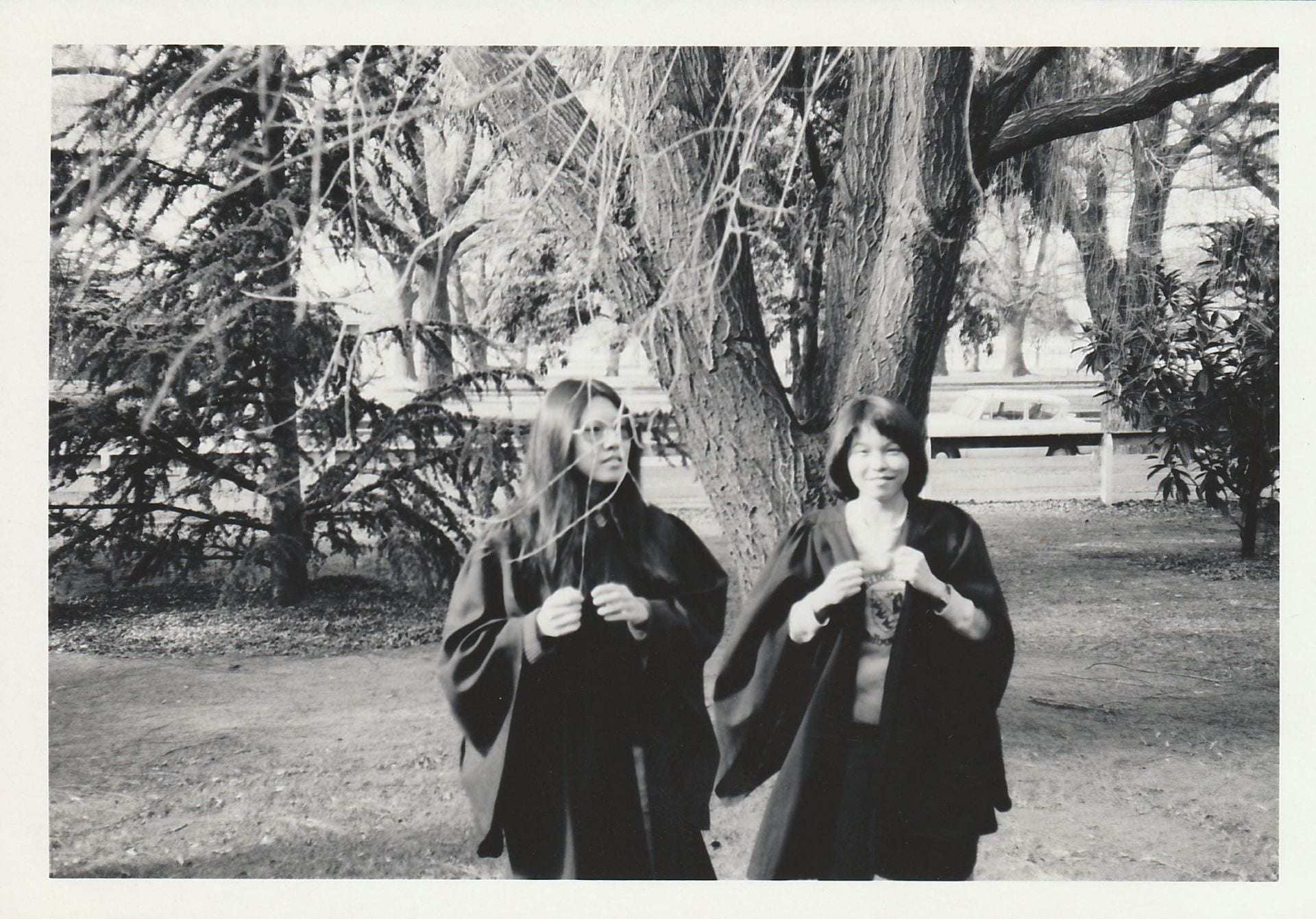 Black and white photograph of two female students dressed in academic gowns
