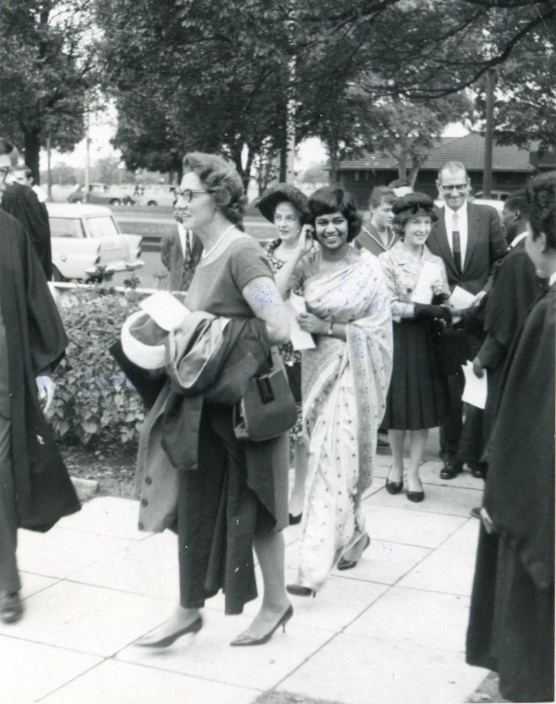 Black and white photograph of a group of people on the pathway leading to the entrance of International House at the University of Melbourne.
