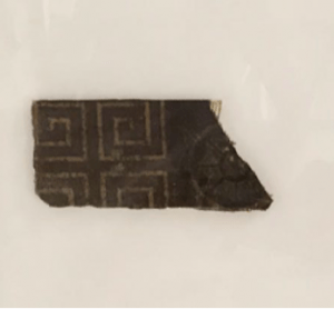 Fragment of historic lino, brown with a gold geometic pattern