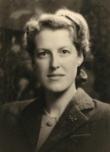 Sepia toned photo of a woman in blaxer staring directly at the camera.
