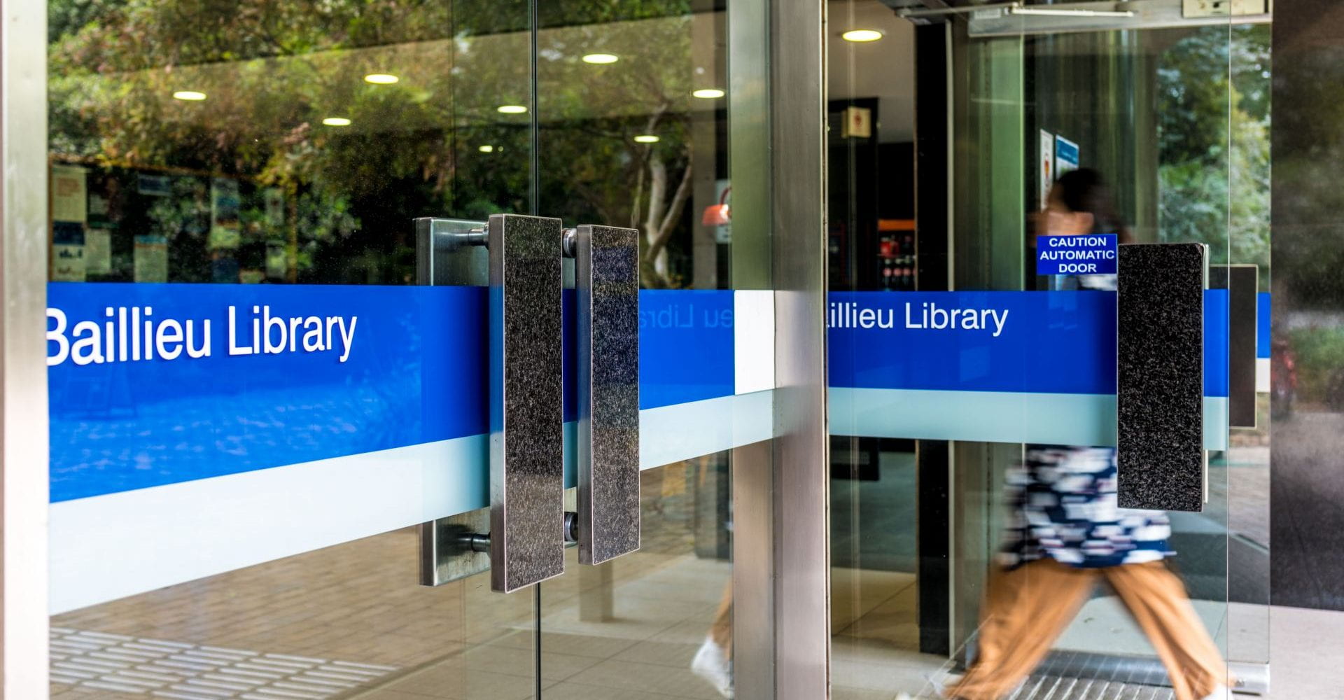 Student entering doors of library
