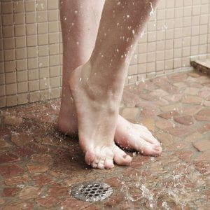 Feet and drain in a running shower